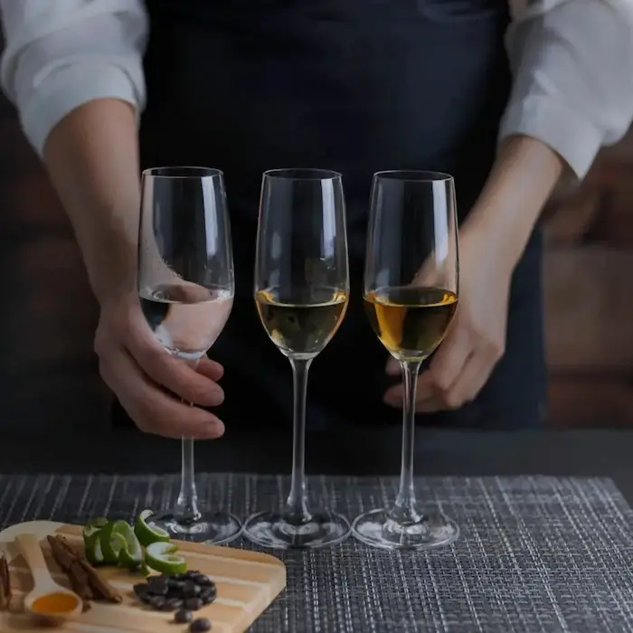 Female presenting two glasses with tequila.